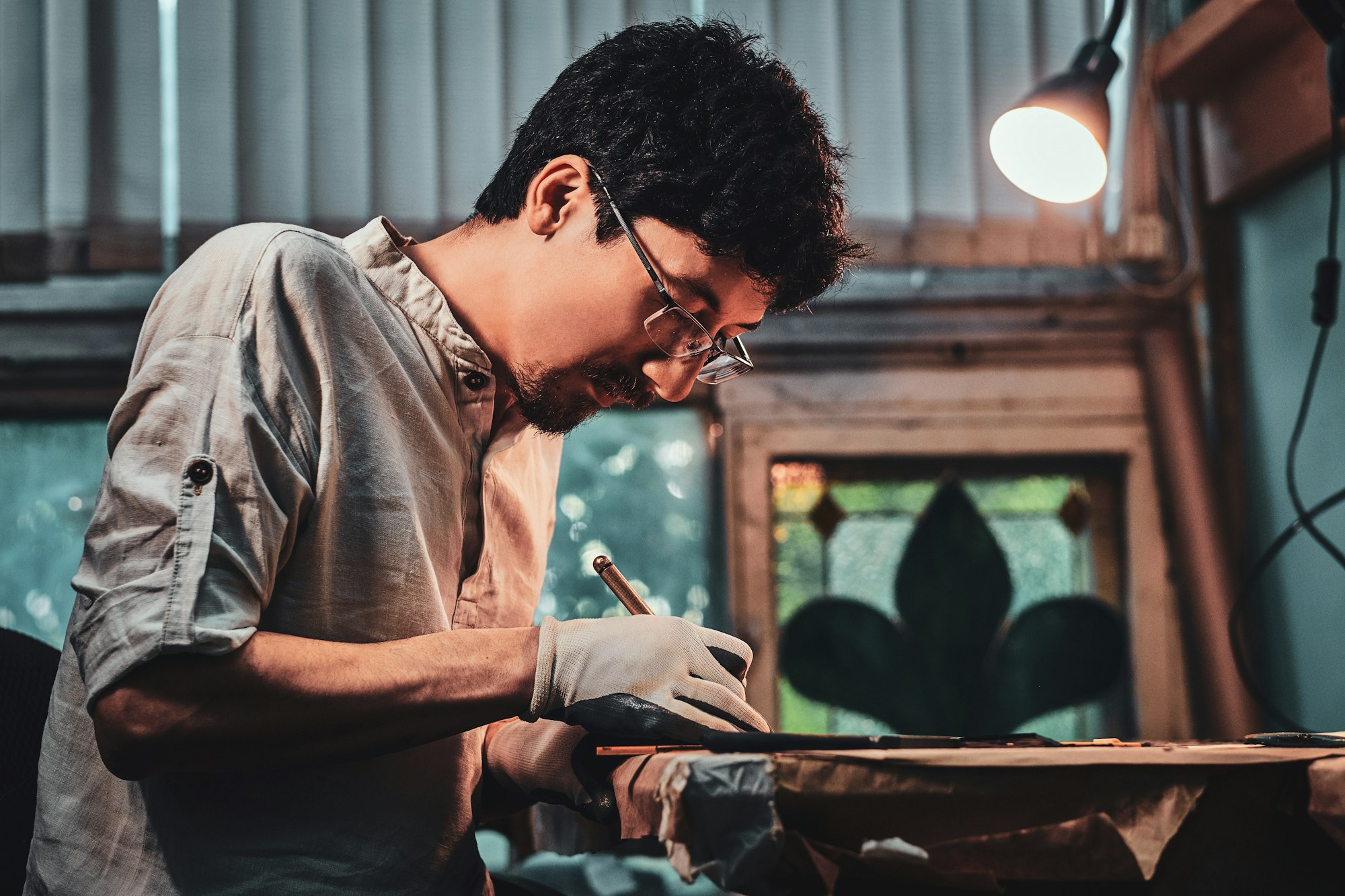 Expirienced diligent man is working on stained glass restoration