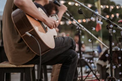 The musician plays and the lead singer sings on stage at the music festival.Concert