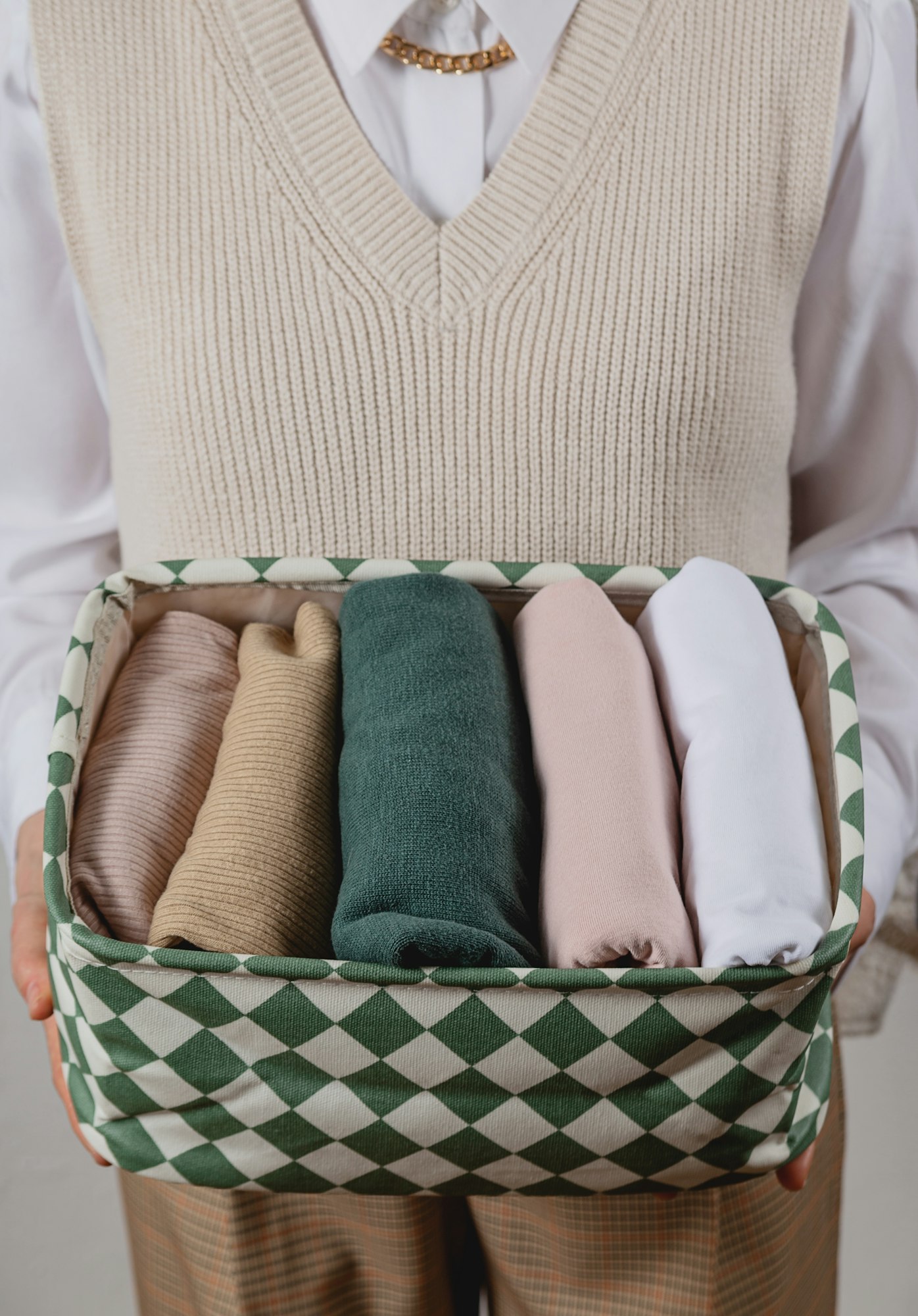 Vertical storage of clothes in a container. In the hands of a woman. Conmari Tidy House concept