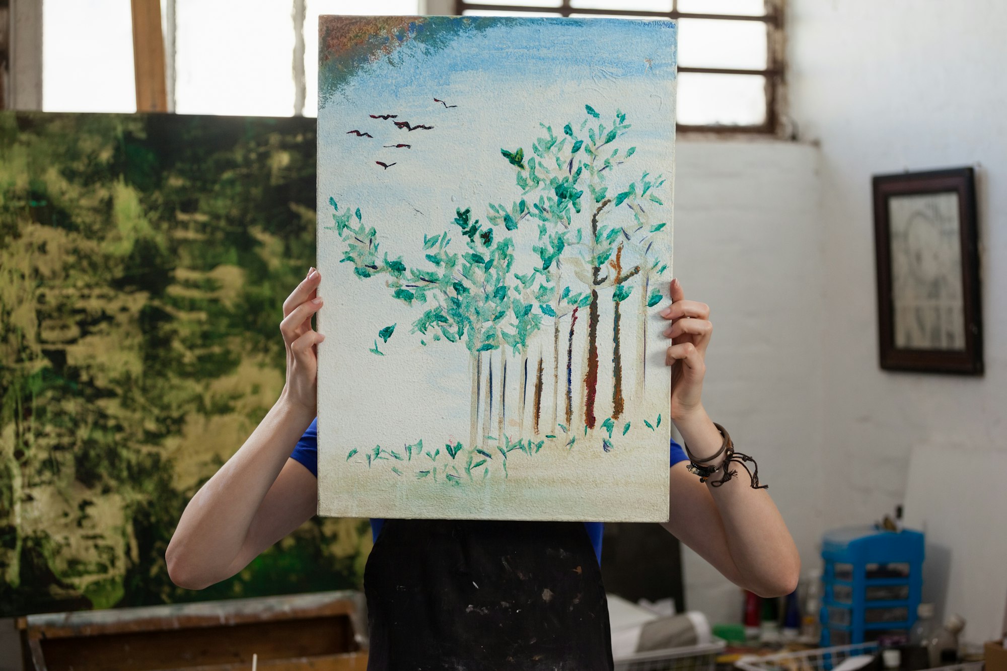 Woman hiding her face behind painting